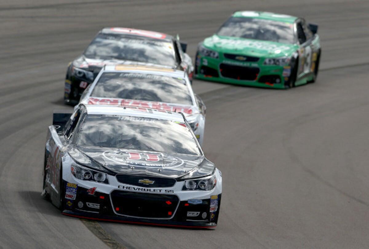 NASCAR driver Kevin Harvick guides his No. 4 Chevrolet around a corner as he leads a pack of cars in the Sprint Cup Series race on Sunday at Phoenix International Raceway.