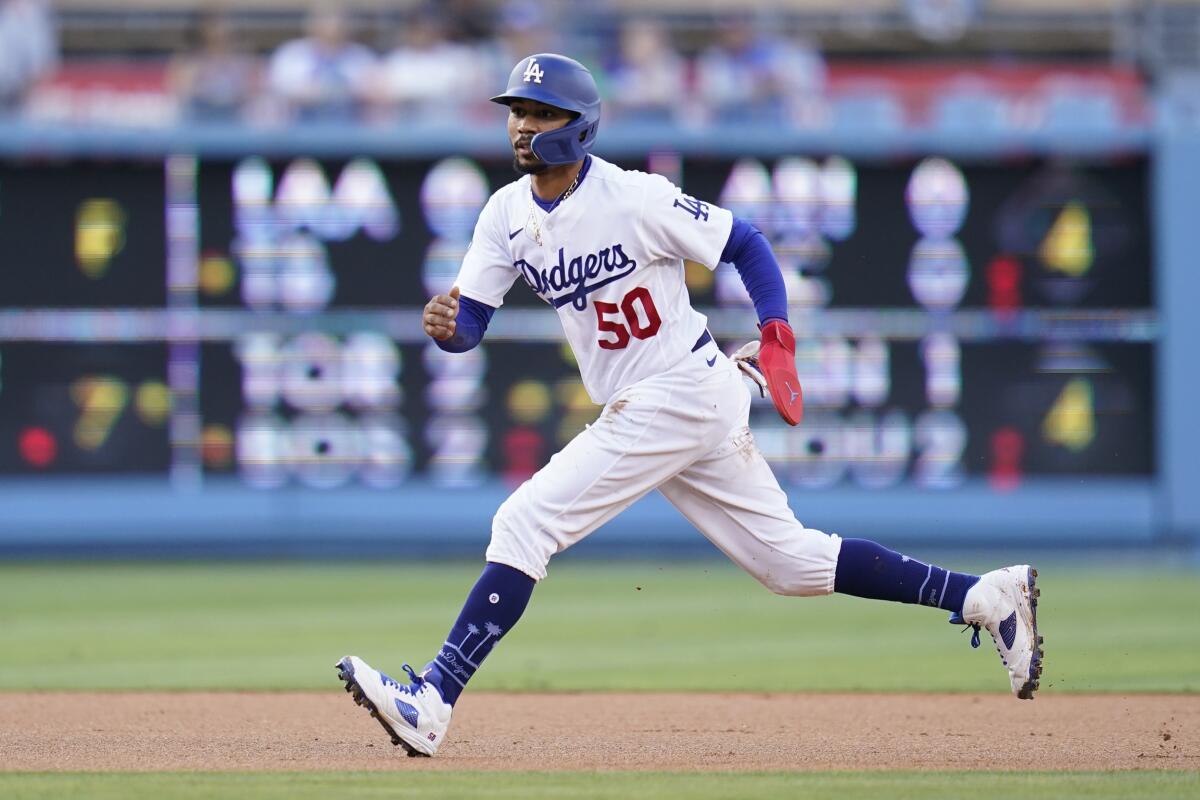 The Dodgers' Mookie Betts (50) runs to third and scores off of a single hit by Freddie Freeman.