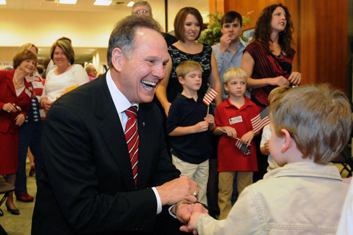 Roy Moore greets Adam DuPre', 3, of Pike Road, Ala., at his election party in Montgomery, Ala.