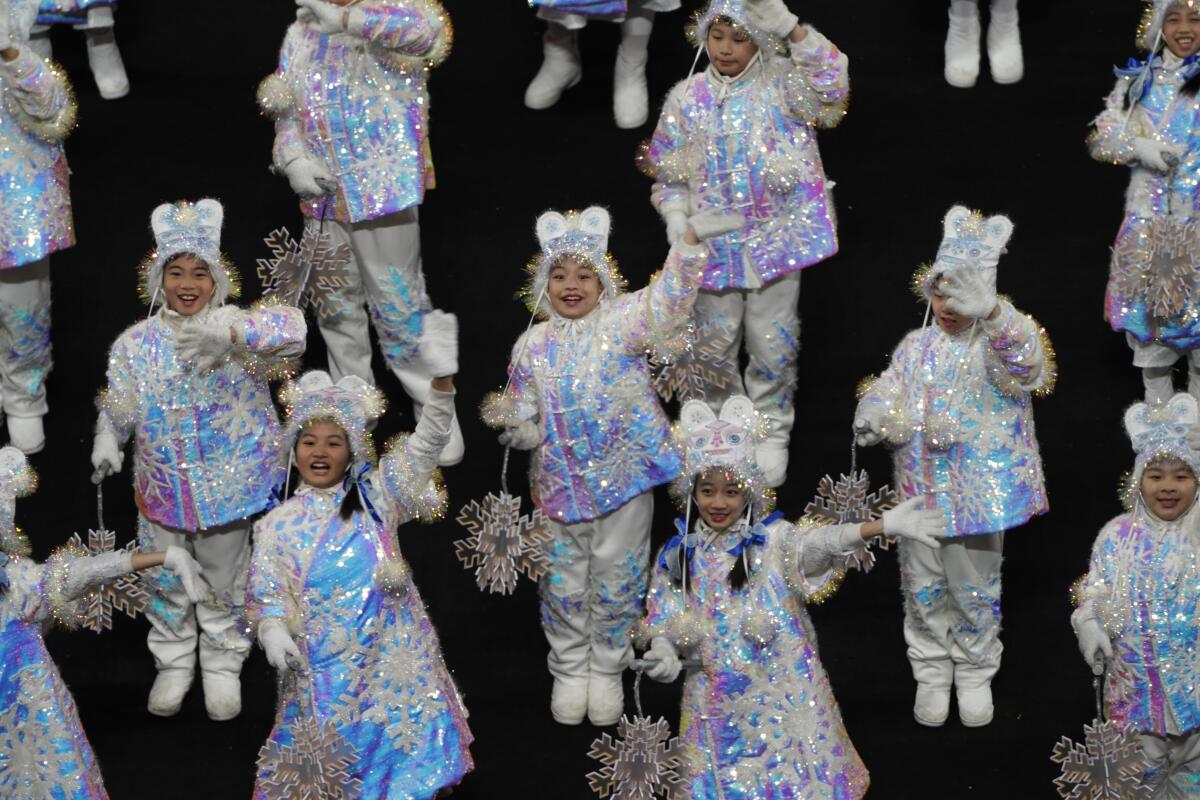 Dancers wear white iridescent costumes at the 2022 Olympics.