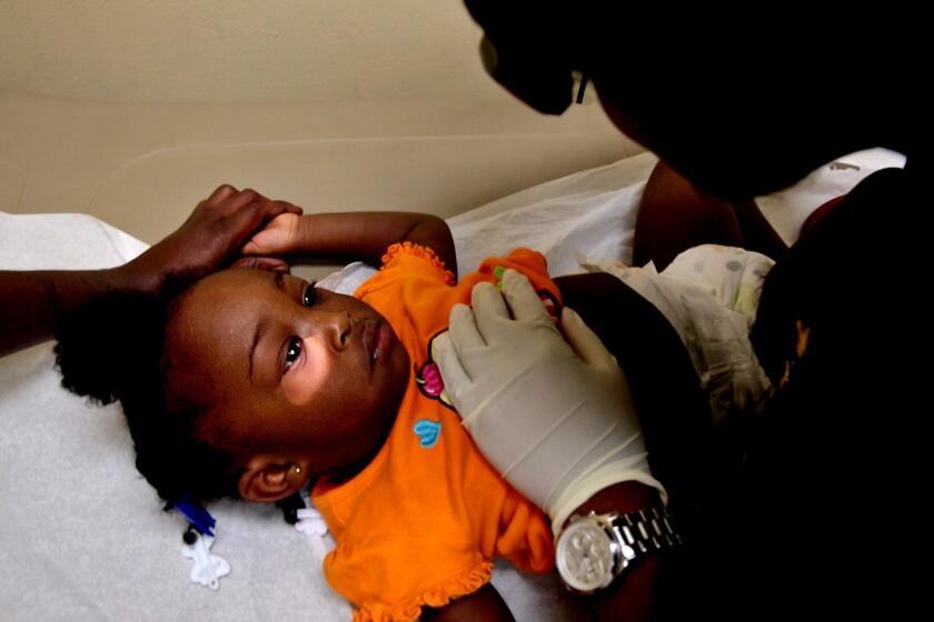Kendra Curtis ,1, gets a checkup at Capitol City Family. The clinic serves thousands of the city's poorest and sickest residents. One in 5 patients has high blood pressure, and 1 in 10 is infected with HIV.