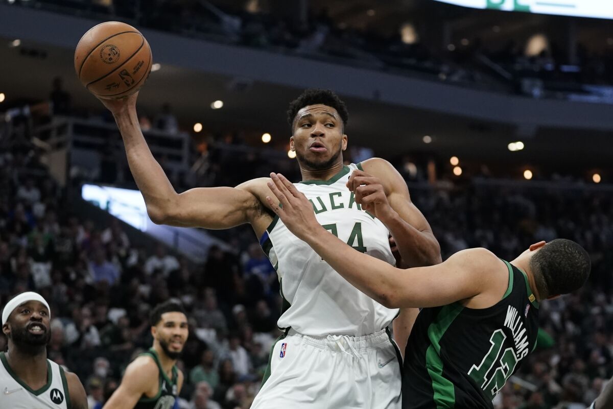 Milwaukee Bucks' Giannis Antetokounmpo rebounds in front o0f Boston Celtics' Grant Williams during the second half of Game 4 of an NBA basketball Eastern Conference semifinals playoff series Monday, May 9, 2022, in Milwaukee. The Celtics won 116-108 to tie the series 2-2. (AP Photo/Morry Gash)