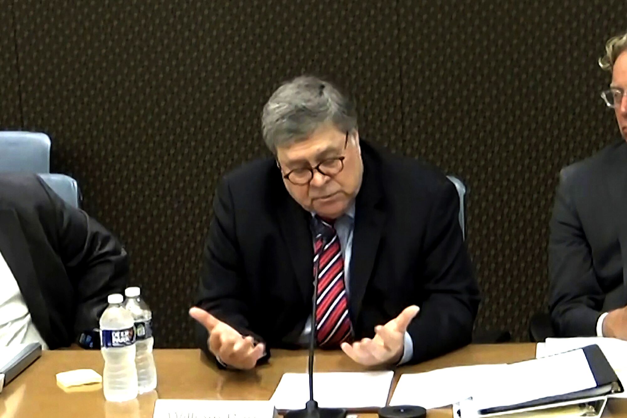 Former Atty. Gen. William Barr speaks into a microphone.