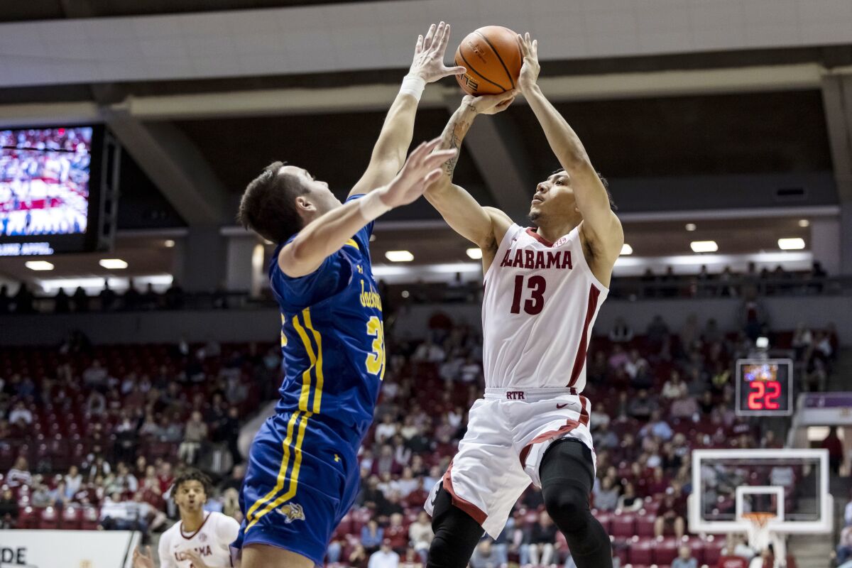 Alabama guard Jahvon Quinerly (13) shoots over South Dakota State guard Alex Arians (34) during the first half of an NCAA college basketball game, Friday, Nov. 12, 2021, in Tuscaloosa, Ala. (AP Photo/Vasha Hunt)