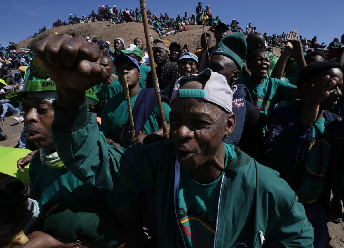 Mine workers sing during the commemoration ceremonies in Marikana, South Africa, Tuesday, Aug. 16, 2022. A somber gathering of about 5,000 people marked the 10th anniversary of what has become known as the Marikana massacre, when police opened fire on striking miners, killing 34 in 2012. (AP Photo/Themba Hadebe)