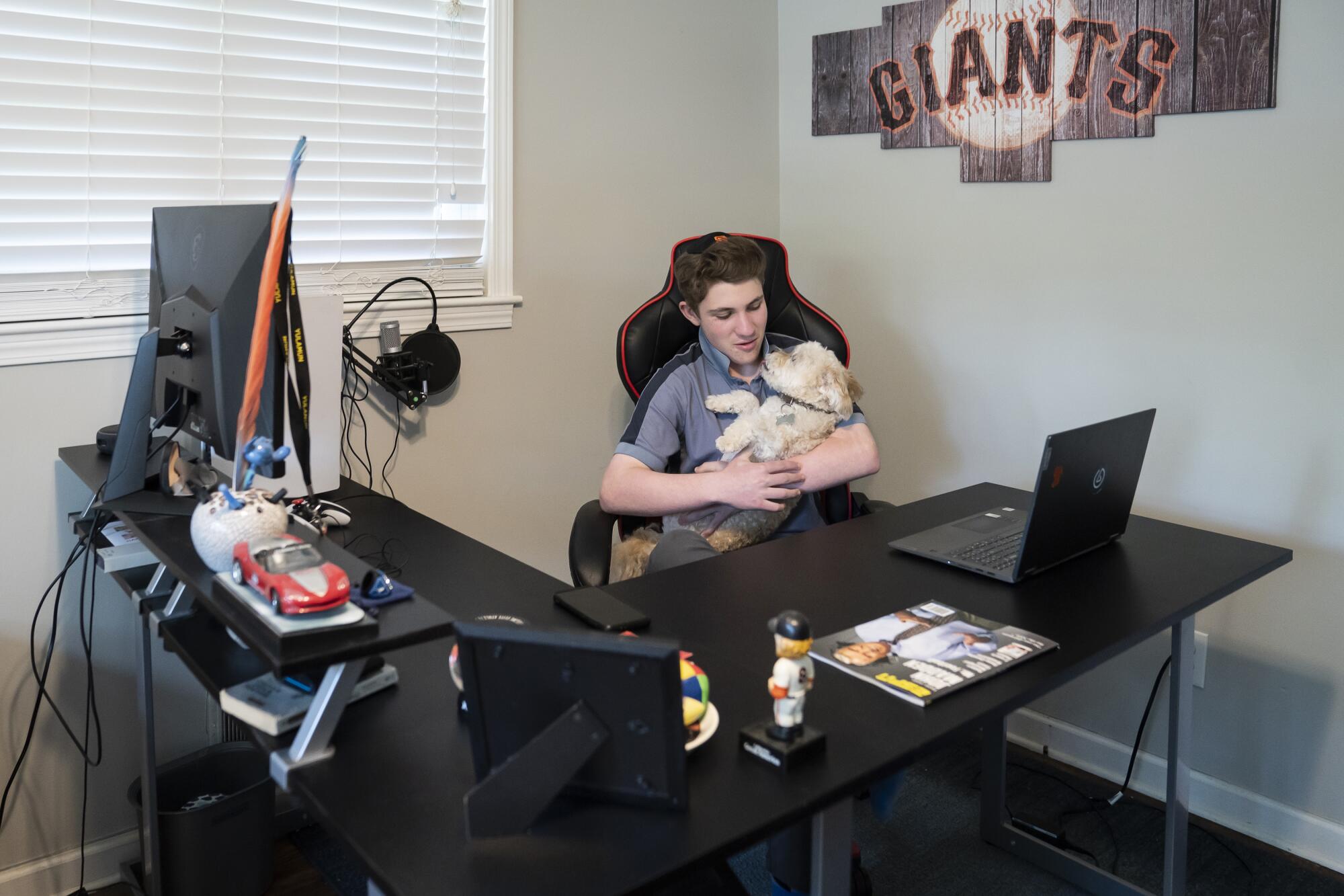 A teenage boy holds his dog.