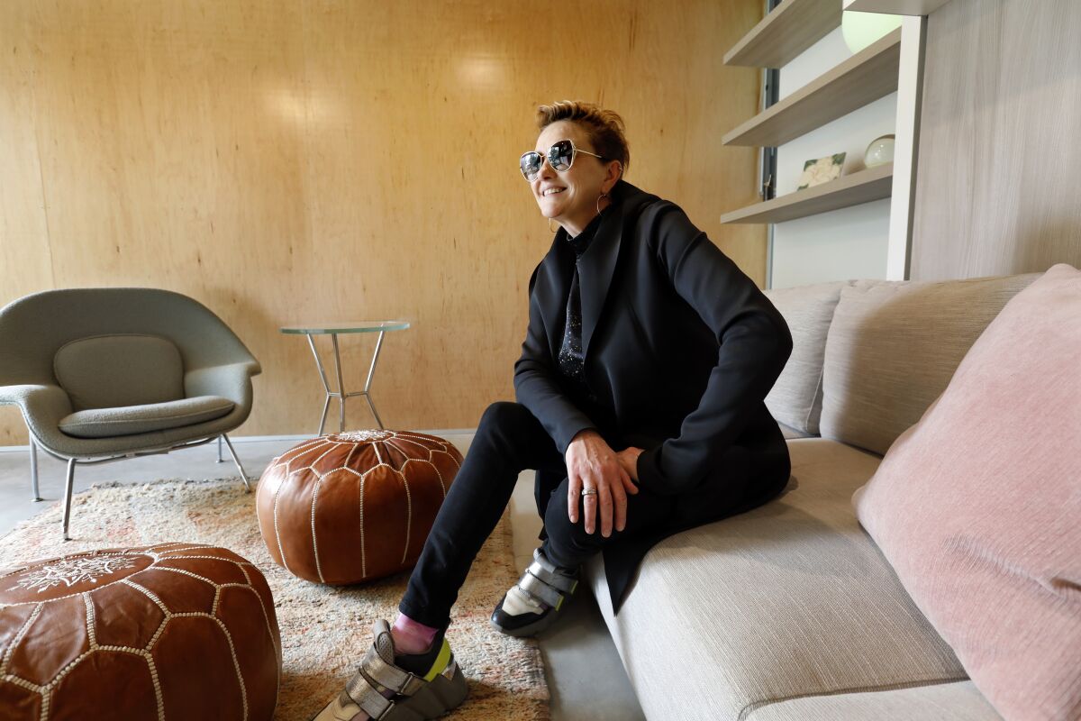 A woman sits on a sofa in a compact ADU.