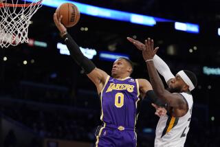 Los Angeles Lakers guard Russell Westbrook, left, shoots as Utah Jazz forward Royce O'Neale defends during the second half of an NBA basketball game Wednesday, Feb. 16, 2022, in Los Angeles. The Lakers won 106-101. (AP Photo/Mark J. Terrill)