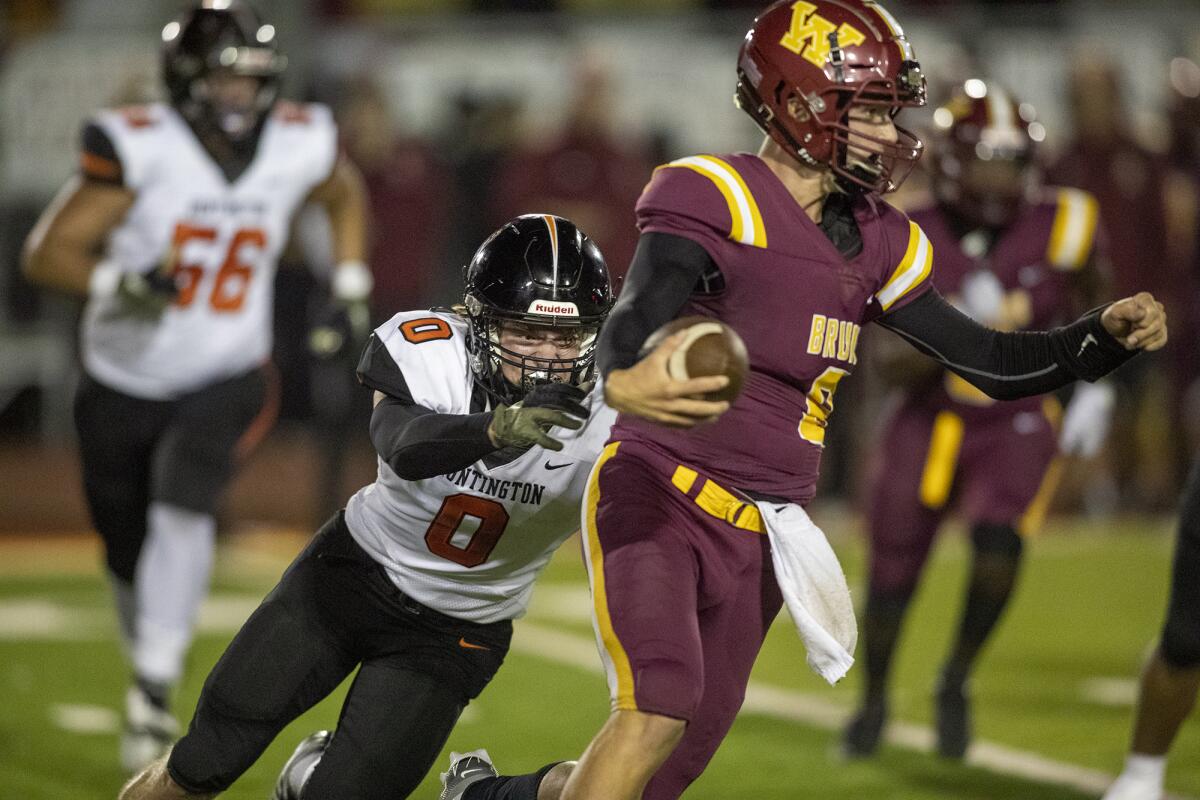 Huntington Beach's Dylan Weber sacks Long Beach Wilson quarterback Ian Bond during Thursday's game.