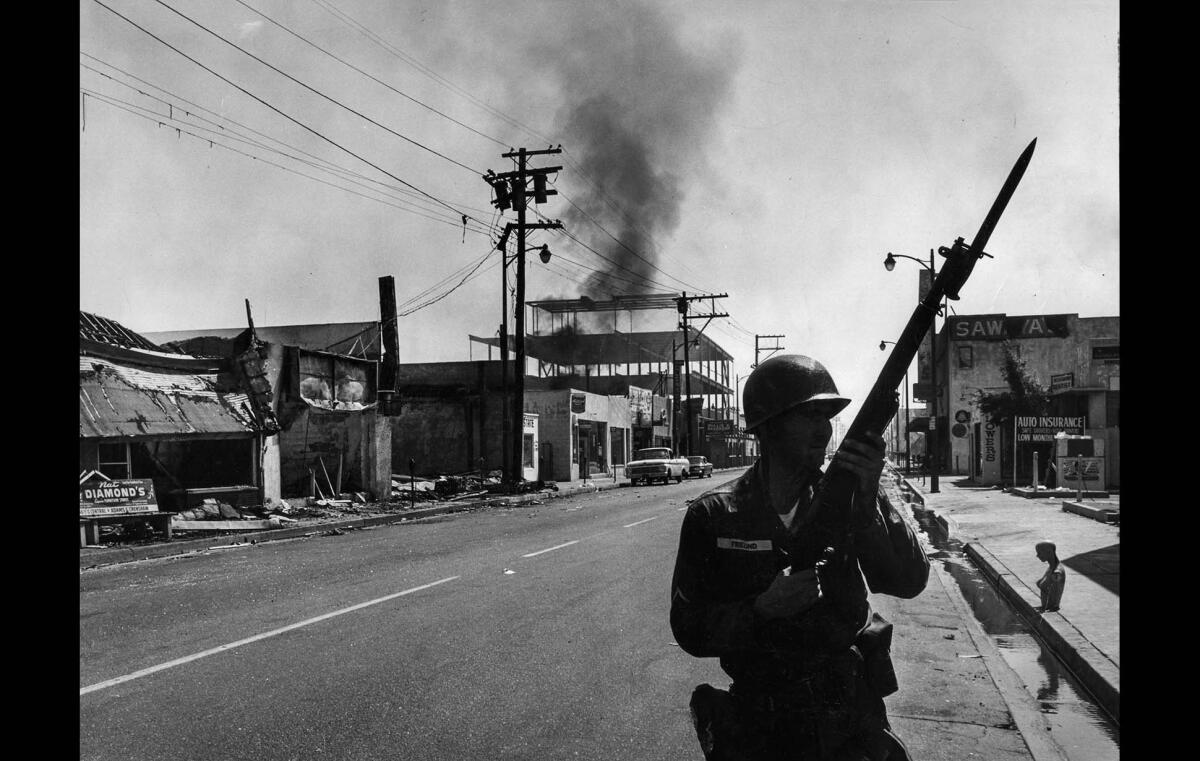 Aug. 14, 1965: A California National Guardsman patrols 103rd Street near Compton Avenue in the Watts business district.