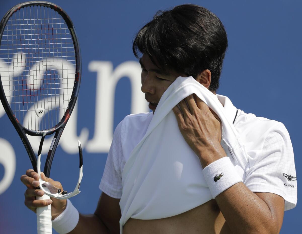 Hyeon Chung wipes his face during his match against Ricardas Berankis, who would retire because of a heat-related illness.
