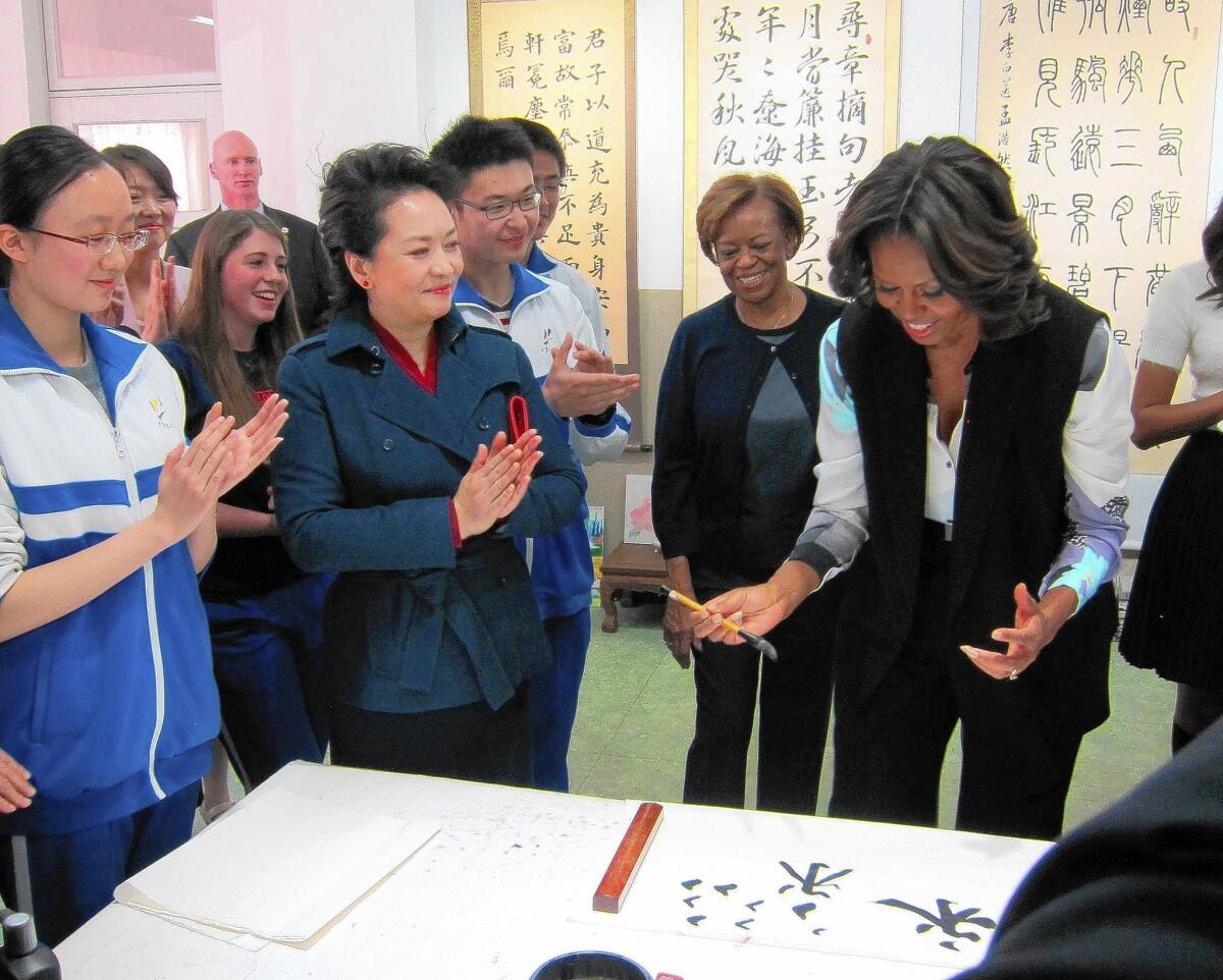 Even First Lady Michelle Obama has tried her hand at writing Chinese characters. Here she's with Peng Liyuan, wife of Chinese President Xi Jinping, at a school in Beijing.