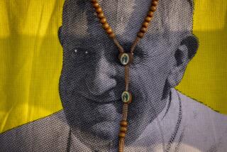 FILE - A necklace showing the Virgin Mary is seen around the neck of a woman wearing a t-shirt with a picture of Pope Francis, as she awaits his arrival at the St. Theresa Cathedral in Juba, South Sudan, Saturday, Feb. 4, 2023. In an extraordinary pushback against Pope Francis, Catholic bishops from Africa to Poland say they will not implement a new Vatican policy allowing blessings for same-sex couples. (AP Photo/Ben Curtis, File)