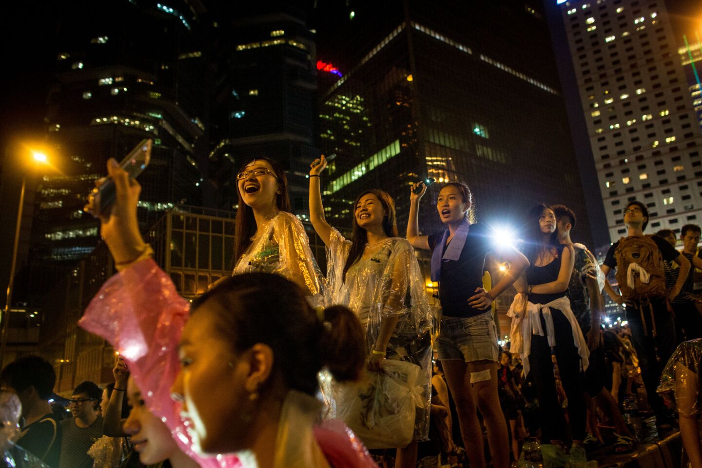 Protesters sing and wave their cellphones after a massive thunderstorm outside the Hong Kong government complex.