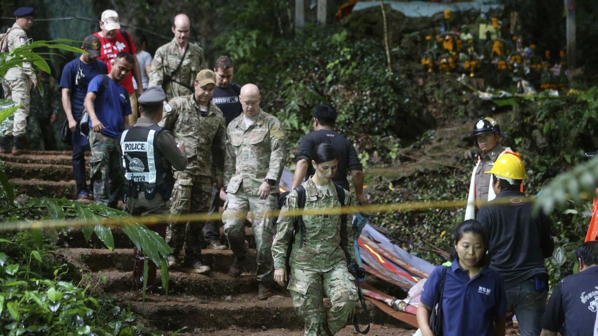 U.S. Special Operations Command Pacific Search and Rescue team personnel exit a cave where a young soccer team and their missing coach are believed to be.
