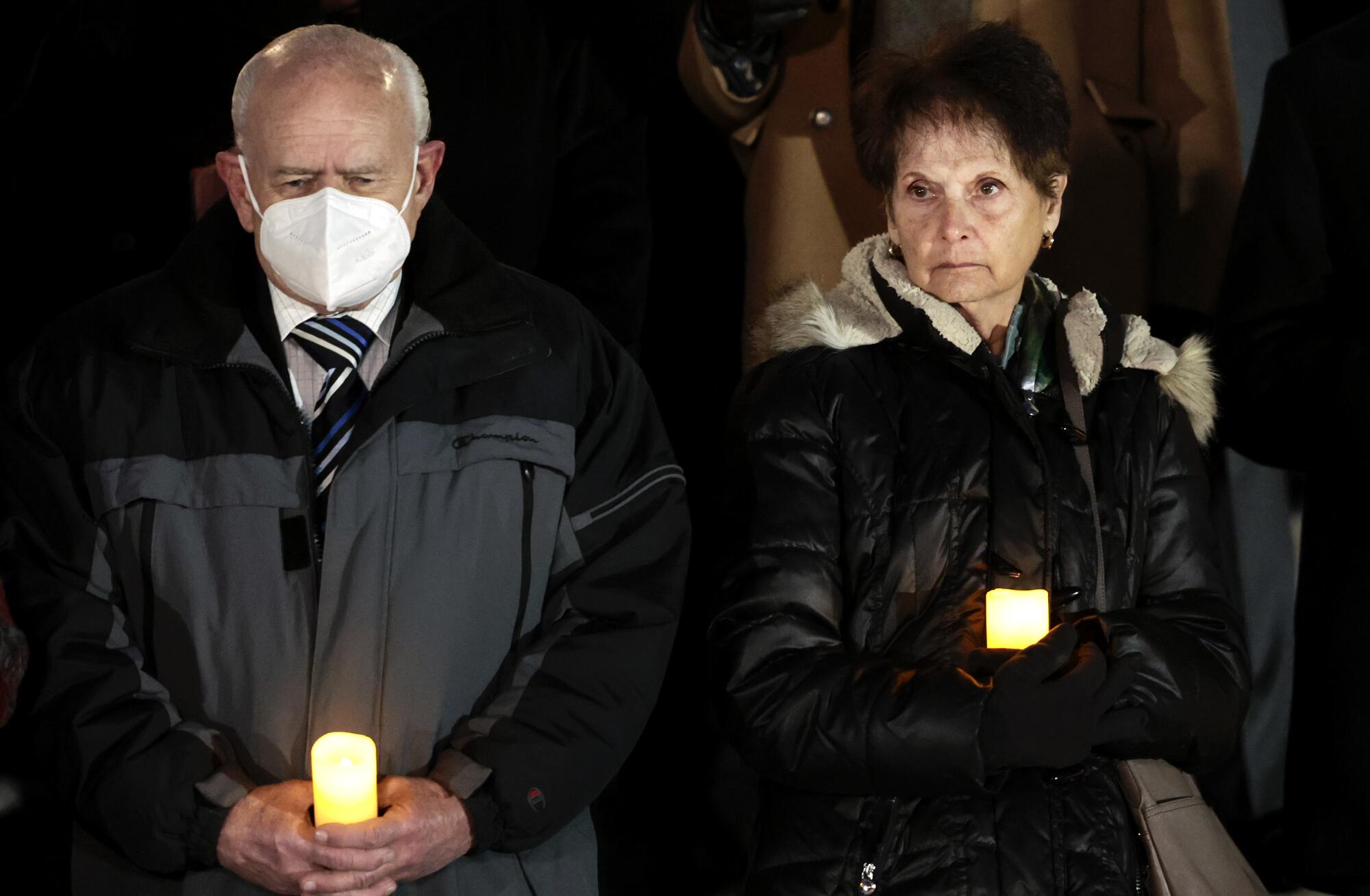 Charles and Gladys Sicknick hold candles at an outdoor vigil