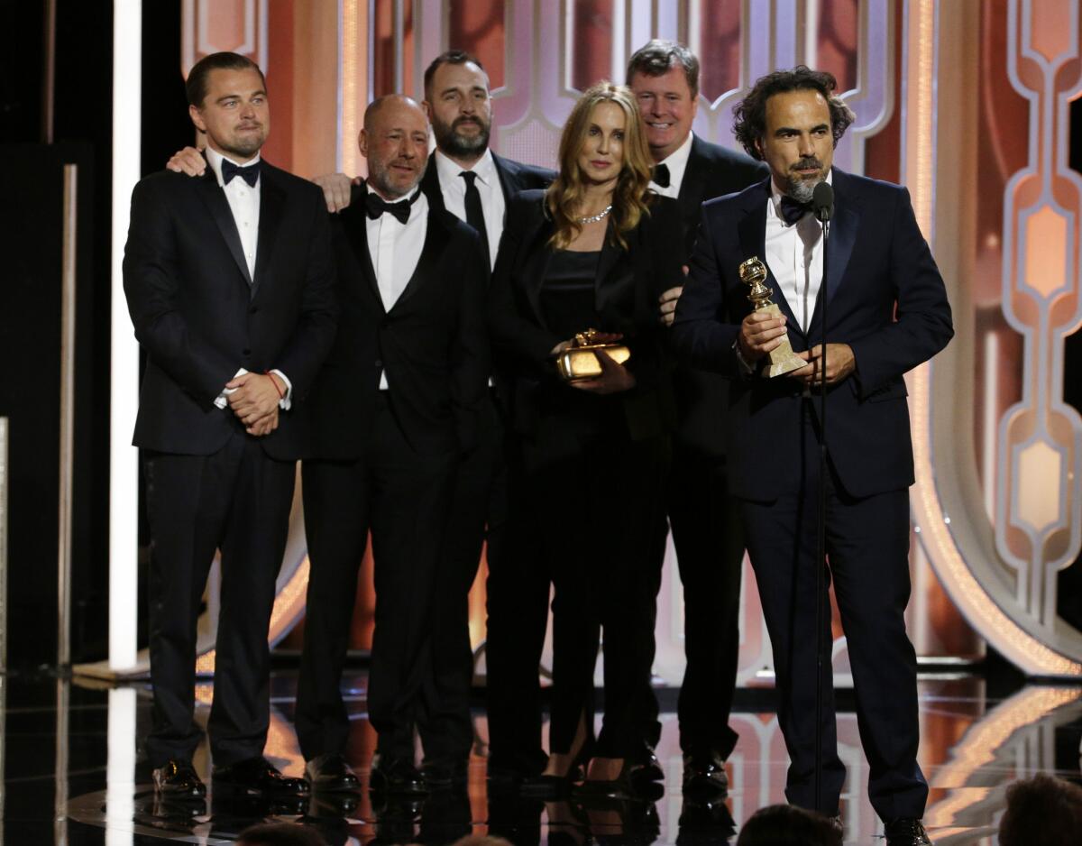 En esta imagen difundida por la NBC, Alejandro González Iñárritu acepta el Globo de Oro a la mejor película de drama por "The Revenant" mientras su astro Leonardo DiCaprio, a la izquierda, y parte de su equipo lo acompaña.