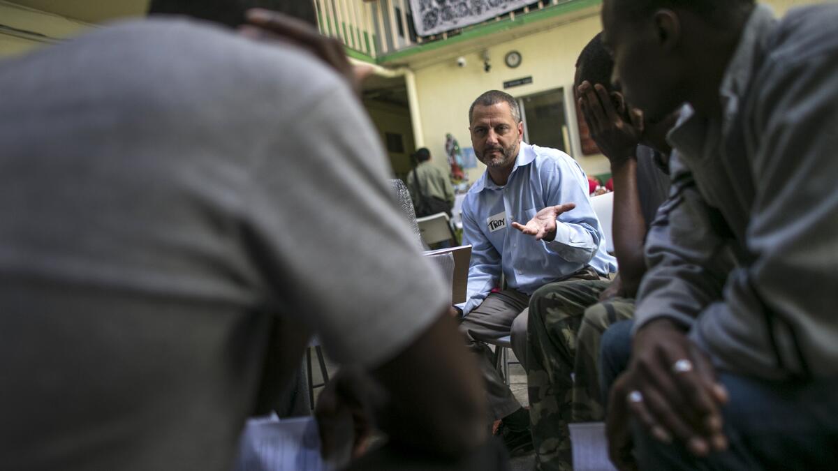 Attorney Troy Elder, speaking Creole, talks to a group of Haitian men seeking to enter the United States.