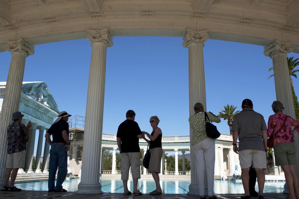 Tourists stand near the large marble columns on the edge of the Greco-Roman style Neptune Pool at Hearst Castle.