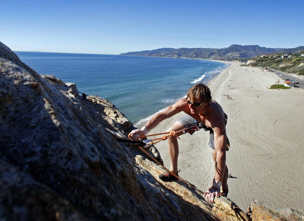 Greg Domanski, 45, of Santa Monica, climbs down Point Dume at Point Dume State Beach in Malibu.