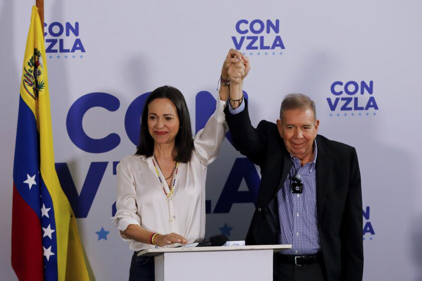 El candidato presidencial de la oposición Edmundo González, a la derecha, y la líder opositora María Corina Machado con las manos unidas en una conferencia de prensa un día después de las elecciones en Caracas, Venezuela, el lunes 29 de julio de 2024. (AP Foto/Cristian Hernández)