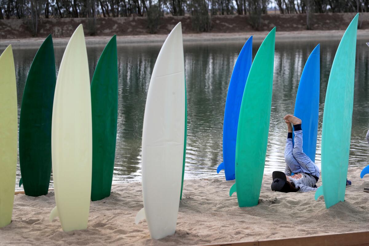 A child plays in the middle of a surfboard art installation at the first-ever World Surf League Founder's Cup at Kelly Slater's Surf Ranch in Lemoore, CA.