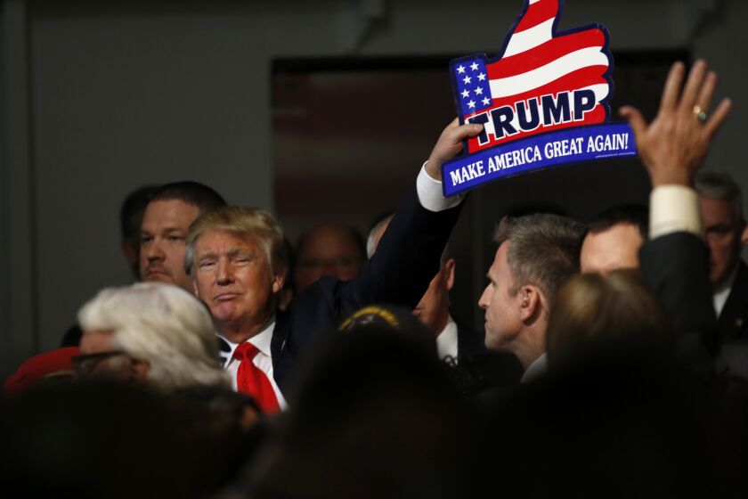 Republican presidential candidate Donald Trump holds one of his signs after a rally in Mount Pleasant, S.C.