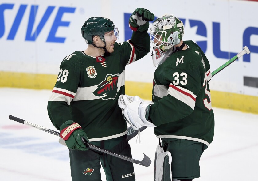 Minnesota Wild's Ian Cole (28) and goaltender Cam Talbot (33) celebrate a win against the Arizona Coyotes after an NHL hockey game Sunday, March 14, 2021, in St. Paul, Minn. (AP Photo/Hannah Foslien)