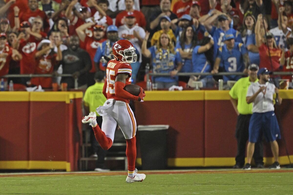 Chiefs cornerback Jaylen Watson (35) looks back as he returns an interception.