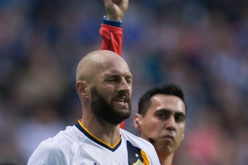 Los Angeles Galaxy's Jelle van Damme receives a yellow card from referee Jair Marrufo during the first half of an MLS soccer game against the Vancouver Whitecaps on Saturday, April 2, 2016, in Vancouver, British Columbia. (Darryl Dyck/The Canadian Press via AP)