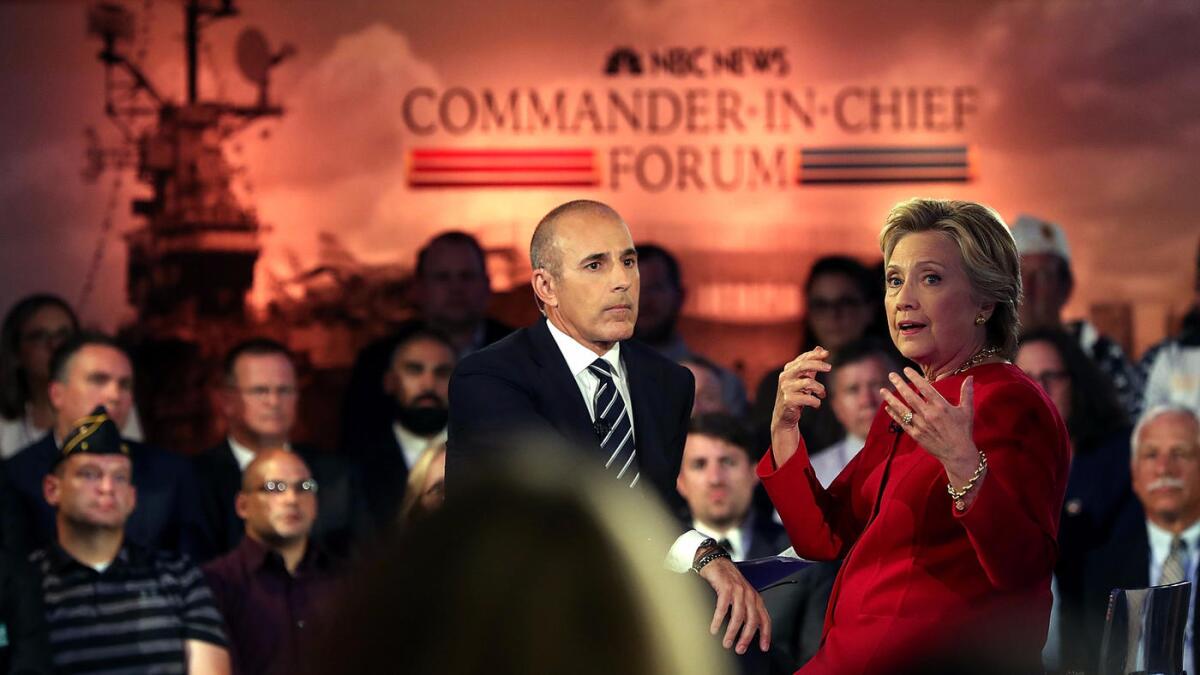 Matt Lauer looks on as Democratic presidential nominee Hillary Clinton speaks during the NBC News Commander-in-Chief Forum.
