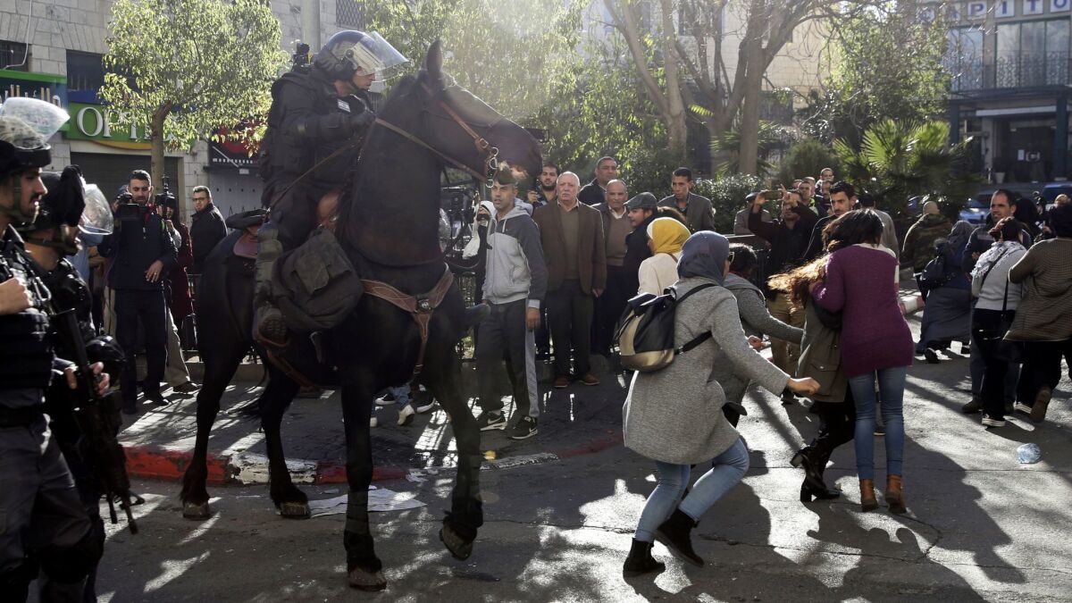 An Israeli mounted police officer charges Palestinians in Jerusalem on Saturday during a protest against President Trump's decision to recognize the city as the capital of Israel.