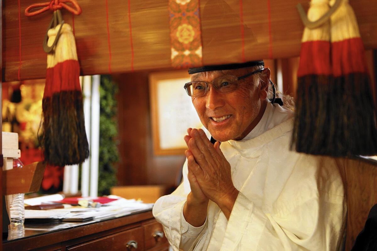 The Rev. Alfred Tsuyuki, 73, head minister of Konko Church of Los Angeles in Boyle Heights, welcomes a member of his congregation after presiding over a monthly Mitama service, honoring the dead. The 85-year-old church is one of four traditionally Japanese churches left in the neighborhood.