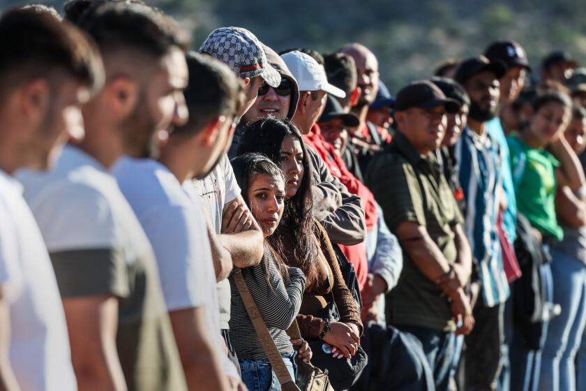Jacumba Hot Springs, CA, Sunday, May 12, 2024 - Migrants gather in a makeshift camp, awaiting transport from Border Patrol, after crossing the border through rocky, mountainous terrain. (Robert Gauthier/Los Angeles Times)