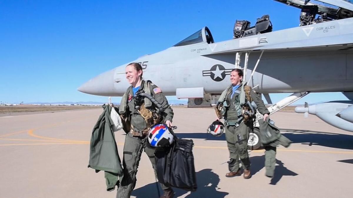 Two naval aviators walk away from their EA-18G Growler jet