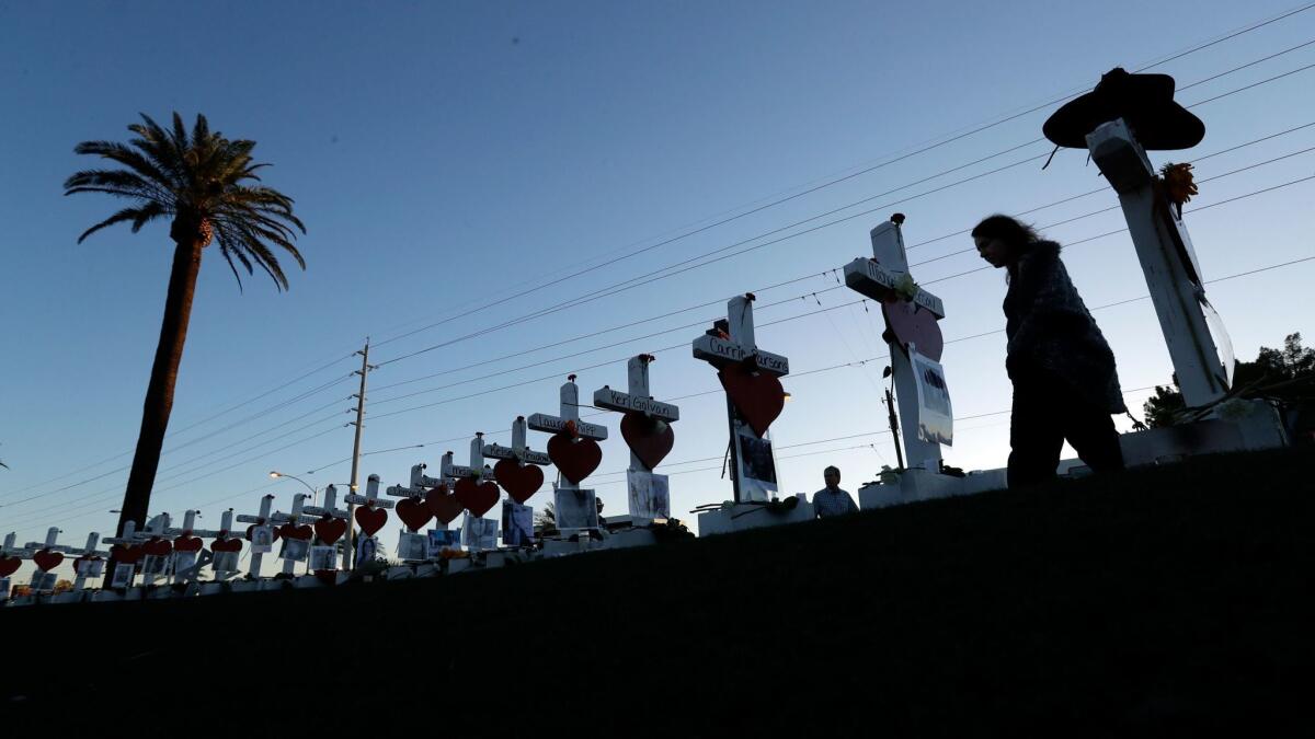 Manuela Barela passes crosses set up to honor those killed during the Oct. 1 mass shooting in Las Vegas.