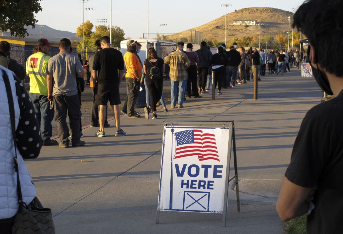 FILE - People wait to vote in-person at Reed High School in Sparks, Nev., prior to polls closing on Nov. 3, 2020. A Las Vegas business executive whose claim of voter fraud was featured by state Republicans after the November 2020 election has agreed to plead guilty to a reduced charge of voting more than once in the same election. (AP Photo/Scott Sonner, File)