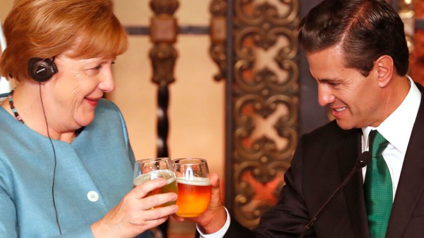 German Chancellor Angela Merkel and Mexican President Enrique Peña Nieto toast after a joint news conference in Mexico City on Friday.