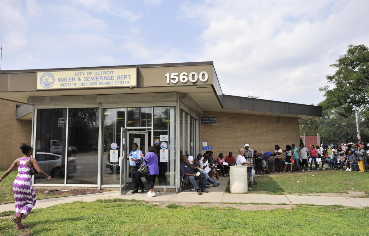 Customers wait outside the Detroit Water and Sewerage Department's Westside Customer Service Center in Detroit on Aug. 25, 2014.