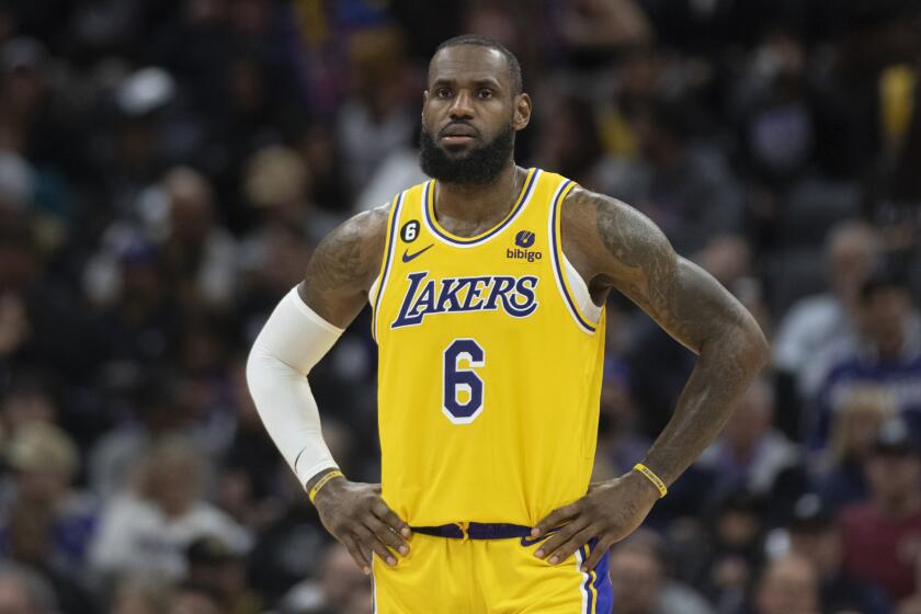 Los Angeles Lakers forward LeBron James stands on court with hands on hips.