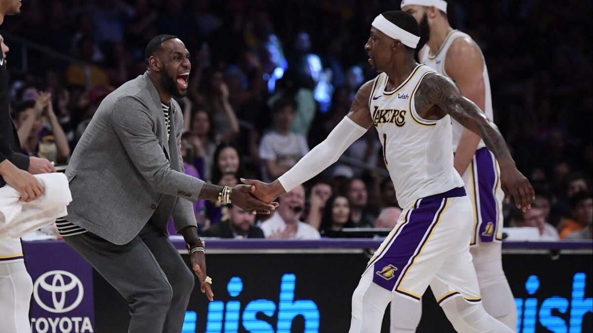 Lakers star LeBron James congratulates teammate Kentavious Caldwell-Pope Sunday against the Utah Jazz.