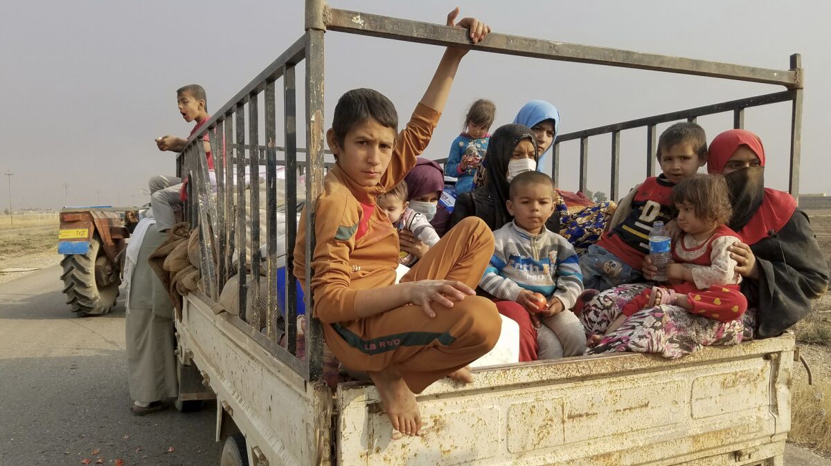 Om Shahad, 22, far right in red head scarf, said she fled her village of Tob Zawa about five miles east of Mosul on Tuesday with her three children with other relatives after living under Islamic State's strict rules for more than two years.