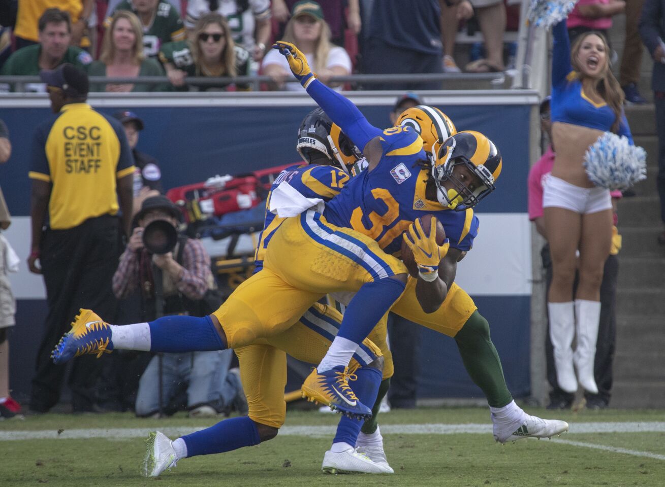Rams' Todd Gurley II (30) is tangled up with Green Bay Packers' Jaire Alexander at the end of a 23-yard first down run late in the 4th quarter on Sunday.