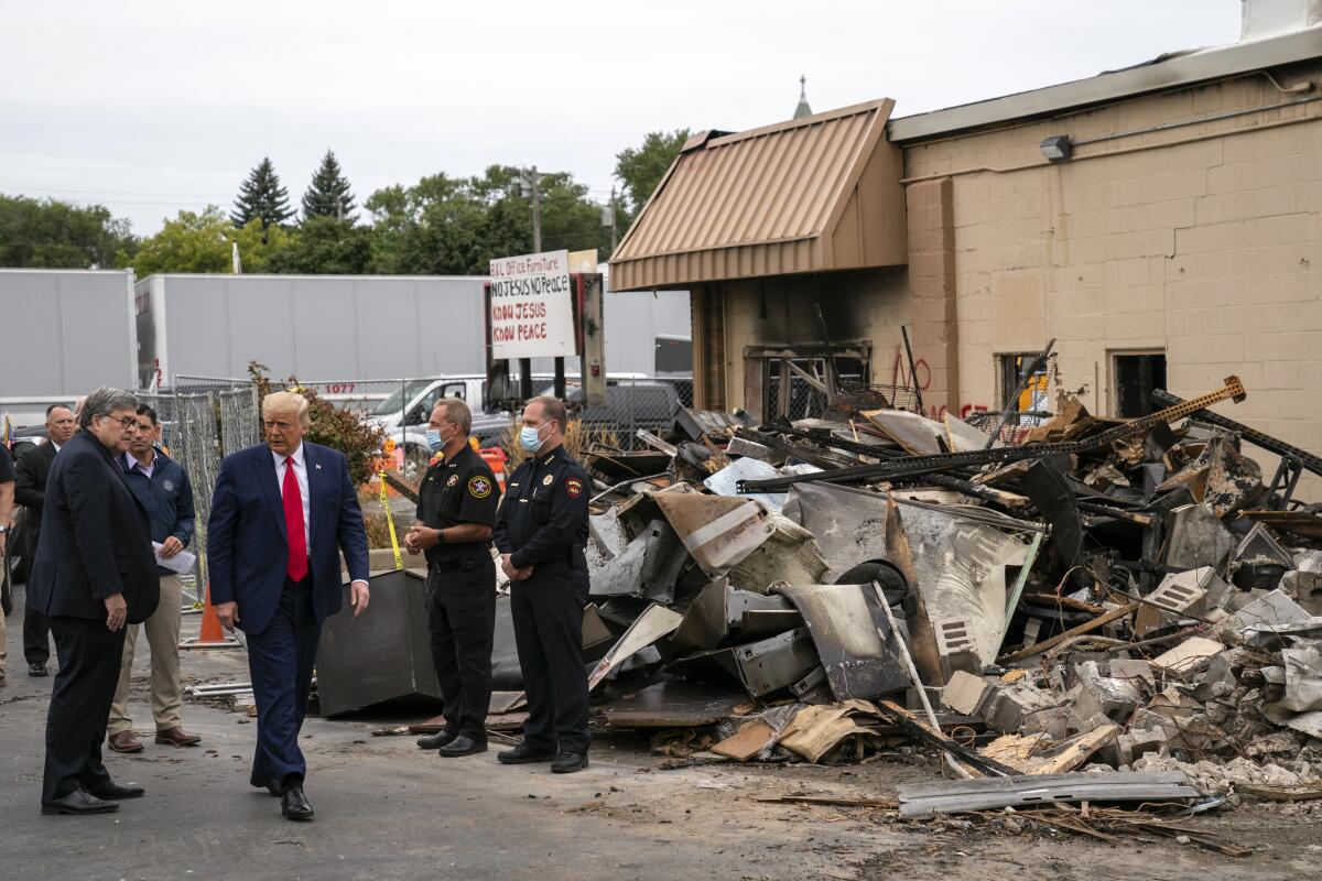 Atty. Gen. William Barr and President Trump on Tuesday tour a block in Kenosha, Wis., that was damaged during demonstrations.