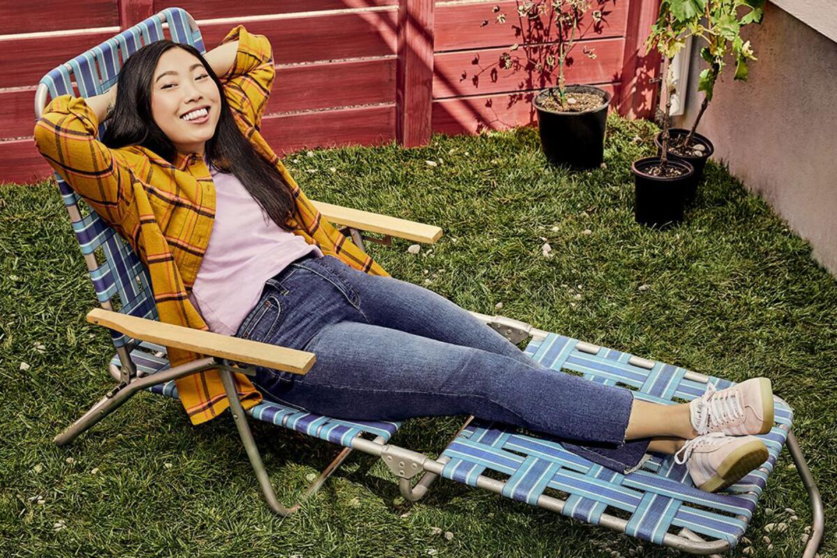 Awkwafina reclines on a lawn chair.