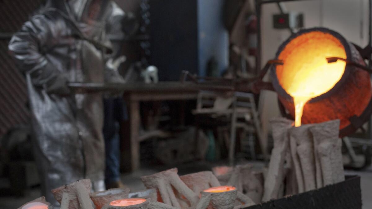 Molten bronze metal is poured into molds in the casting of the solid bronze Actor statuette at American Fine Arts Foundry in Burbank.