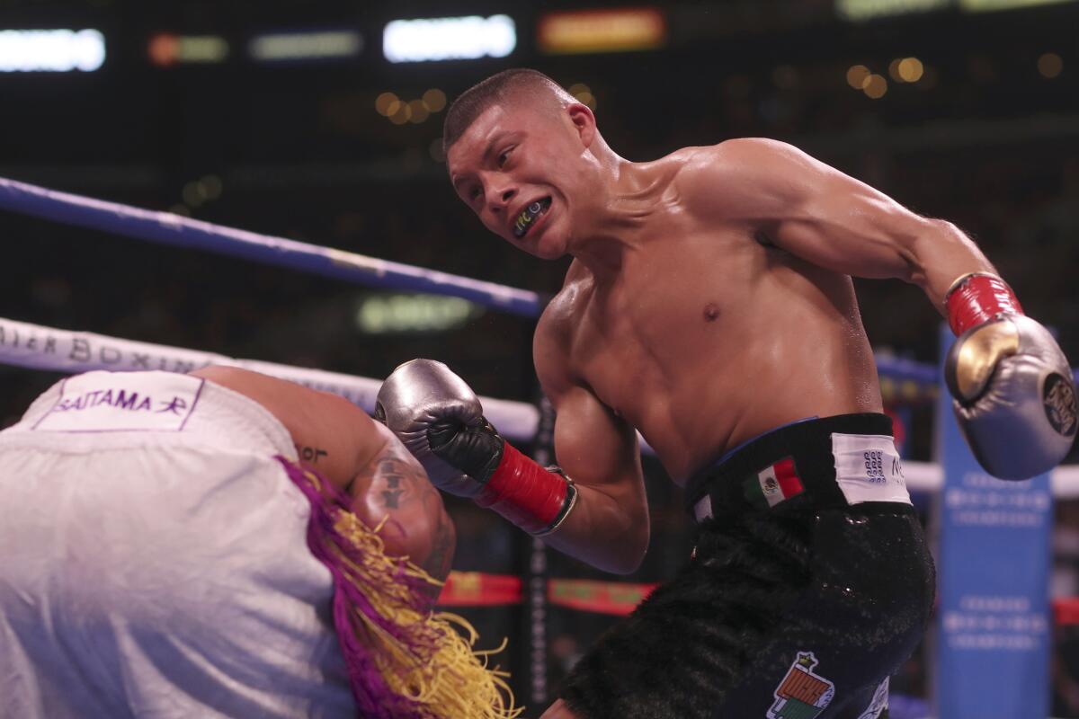 Gervonta Davis, left, receives a punch from Isaac Cruz during their WBC lightweight title boxing bout.