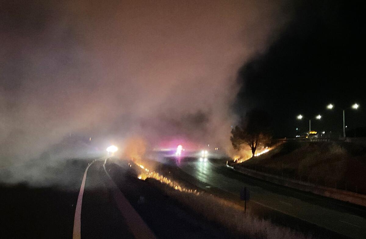 Headlights from cars driving on a smoky road at night