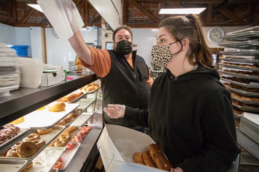 LAKESIDE, CA - DECEMBER 31: Owner and operator of MaryOs Donuts and Coffee, Joel Scalzitti takes customerOs orders along side Faith Perkins on Thursday, Dec. 31, 2020 in Lakeside, CA. (Jarrod Valliere / The San Diego Union-Tribune)