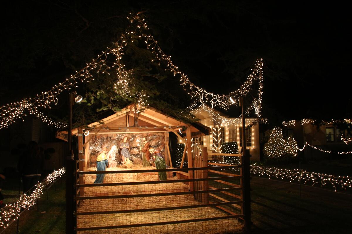 A manger scene outside a decorated home